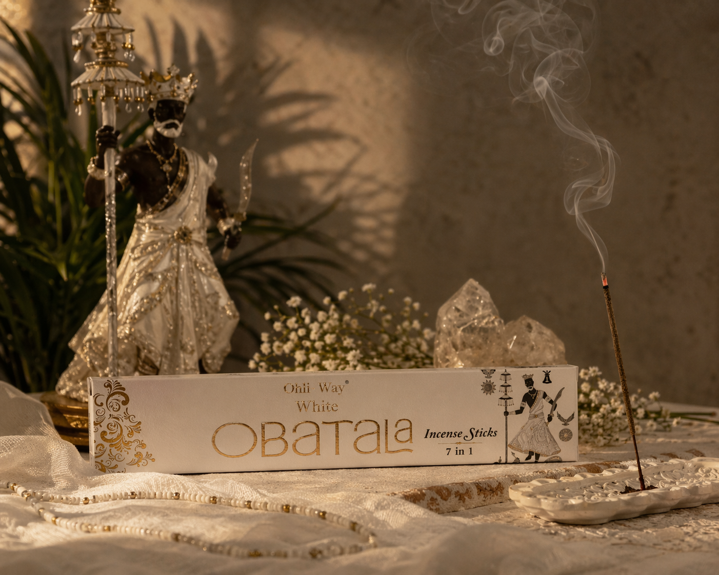 Obatala incense sticks packaging with a smoking incense stick and statue in the background.