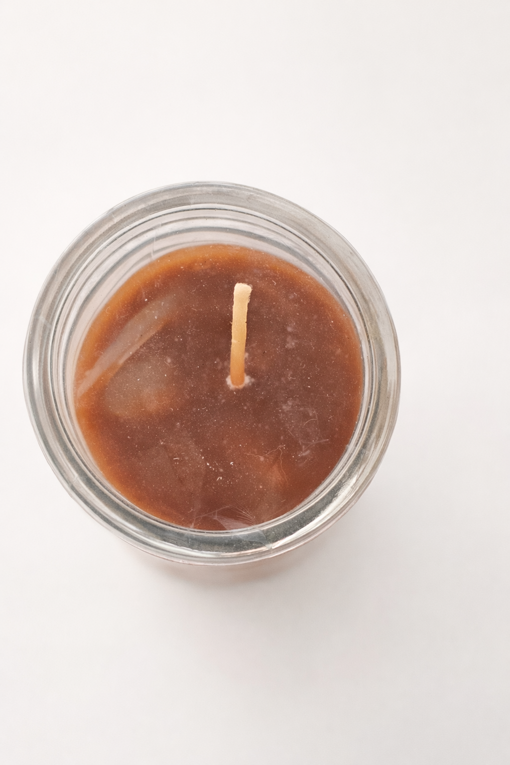 Candle in a glass jar with a wick on a white background