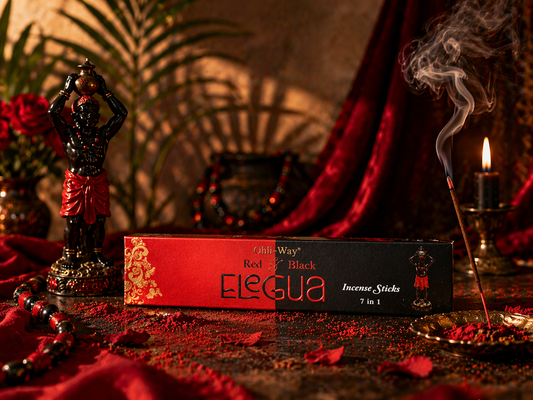 Elegua incense sticks packaging with a statue and candle on a dark background