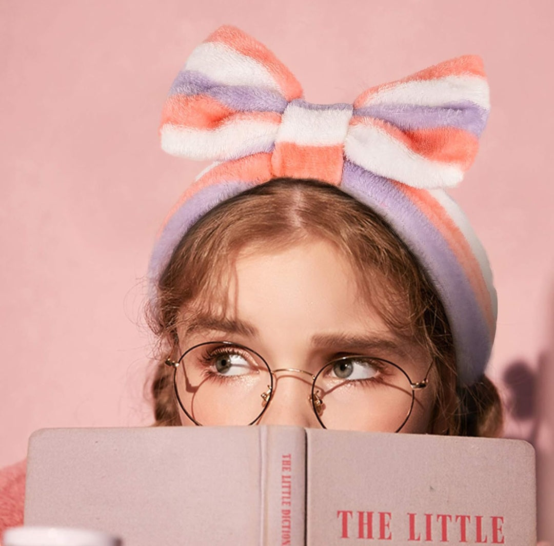 Lady reading book with a coral purple and white headband.