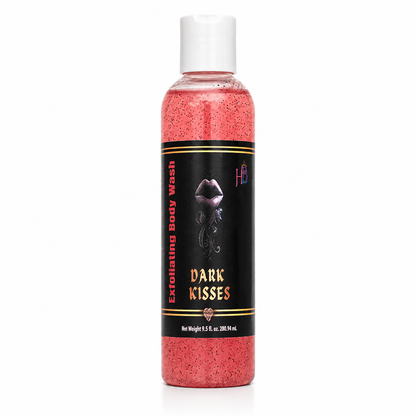 A bottle of exfoliating body wash with pink-red liquid inside, featuring a black label with gold and white text that reads 'Dark Kisses' and a white cap, set against a plain white background.