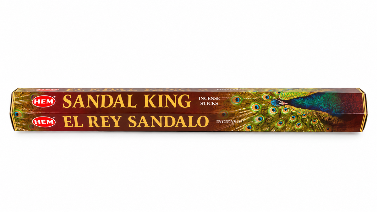 A long rectangular box of HEM Sandal Sandal King incense sticks, featuring a peacock feather design on a reddish-brown background with gold lettering.