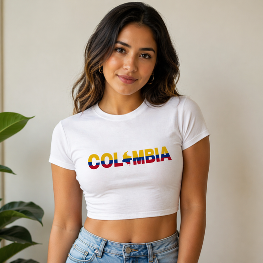 Woman wearing a white t-shirt with 'COLOMBIA' printed in colorful letters, standing indoors.