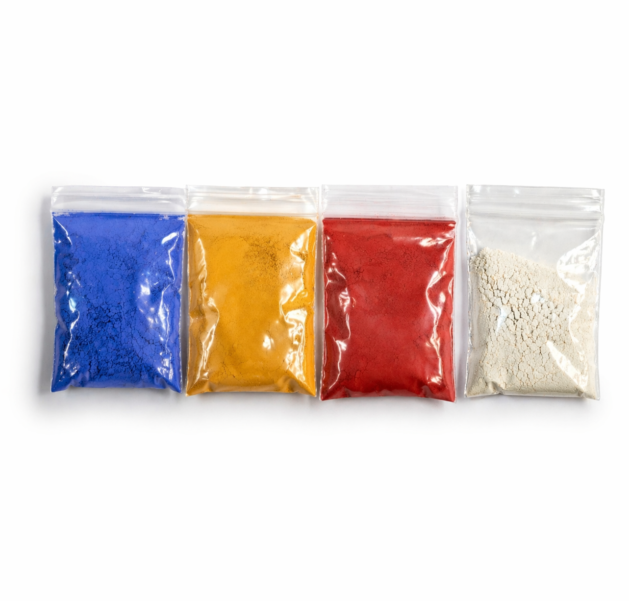 Four small plastic bags with different colored powders on a white background