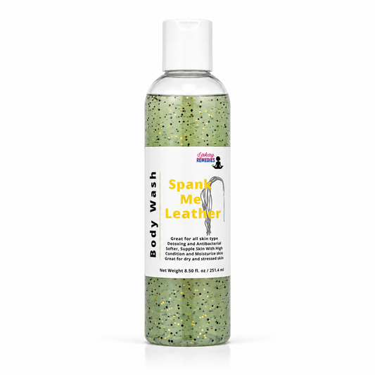 A clear plastic bottle of body wash with a white cap and a white label reading 'Body Wash' and 'Spank Me Leather' in yellow text. The liquid inside is green with black and gold glitter.