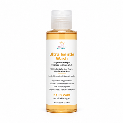 A bottle of Her  Beauty Factory Ultra Gentle Wash, a fragrance-free pH-balanced intimate wash, shown on a clean white background. The bottle contains a golden-amber liquid and features a white label with orange and black text.
