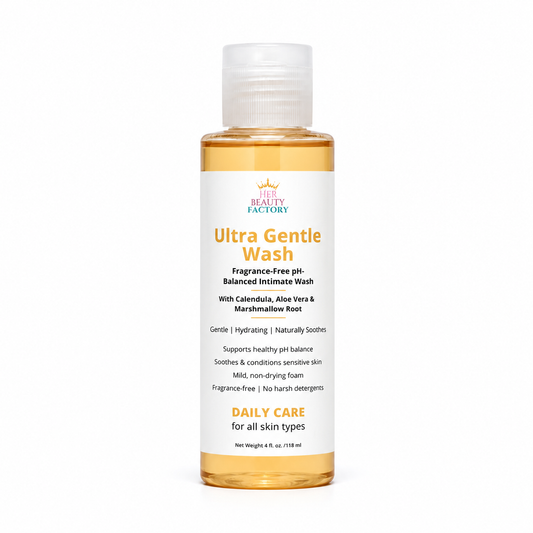 A bottle of Her  Beauty Factory Ultra Gentle Wash, a fragrance-free pH-balanced intimate wash, shown on a clean white background. The bottle contains a golden-amber liquid and features a white label with orange and black text.