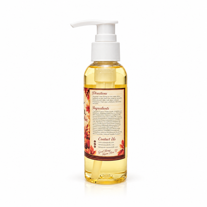 A clear plastic pump bottle filled with golden yellow oil, featuring a white pump dispenser and a decorative label with red and brown botanical illustrations. The brand name 'Goddanger Skin Co.