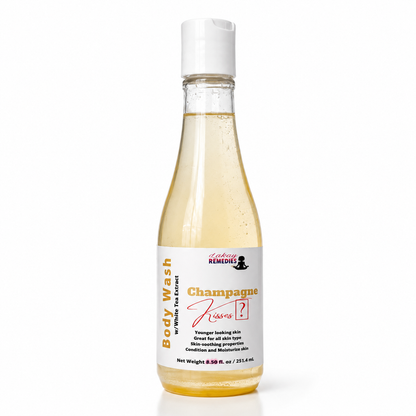 A bottle of Body Wash by Lakay Remedies in the 'Champagne Kiss' scent, featuring a clear bottle filled with pale golden liquid and a white cap, set against a plain white background.