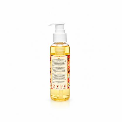 A clear plastic pump bottle filled with golden yellow liquid, featuring a white pump dispenser and a decorative label with red and orange floral patterns, shown against a plain white background.