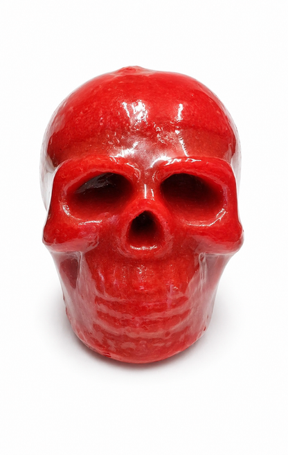 Red skull-shaped candle on a white background