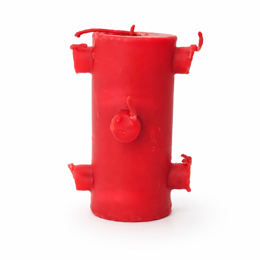 Red cylindrical candle with wing-like protrusions on a white background
