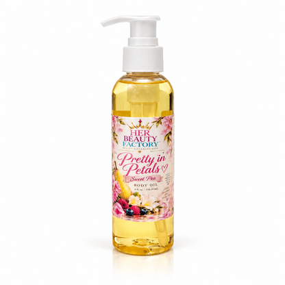 A bottle of Her Beauty Factory Pretty in Petals Sweet Pea Body Oil with a white pump dispenser and a floral label, filled with yellow oil, on a white background.