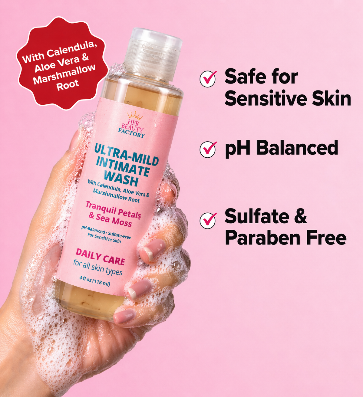Bottle of ultra-mild intimate wash with hand holding it, on a pink background