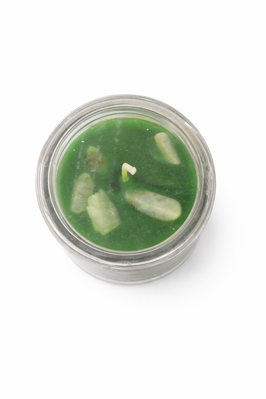 Green candle in a glass jar on a white background