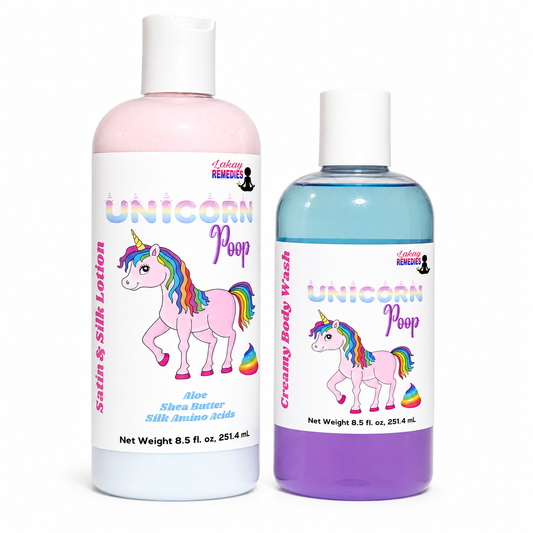 Two bottles of Lakay Remedies 'Unicorn Poop' body wash and satin & silk lotion. The larger bottle on the left is a translucent light pink bottle with a white cap and a white label featuring a pink unicorn with a rainbow mane.