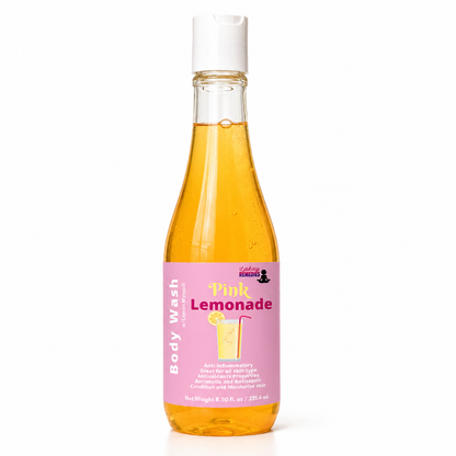 A bottle of Pink Lemonade body wash by LakayRemedies, filled with a golden-yellow liquid and featuring a pink label with a lemonade graphic, set against a plain white background.