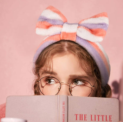 Lady reading book with a coral purple and white headband. 